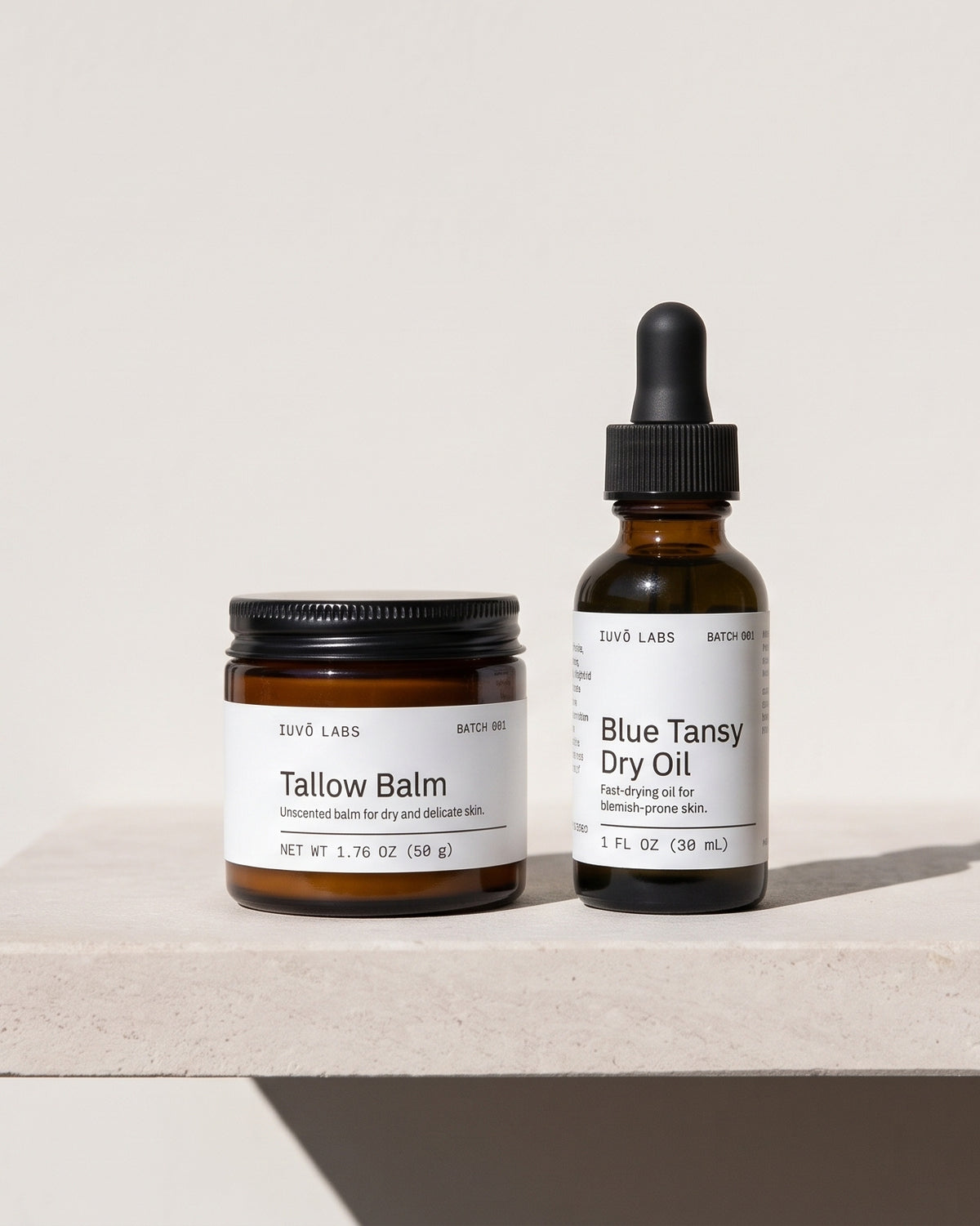 Tallow Balm 50 g and Blue Tansy Dry Oil 30 mL on a stone ledge in hard desert sun